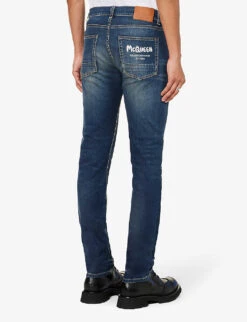 Alexander McQueen Graffiti Brand-embroidered Tapered-leg Regular-fit Stretch-denim Jeans -Selfridges Store R04153535 BLUEWASHED ALT03